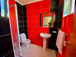 bagno rosso con servizi igienici e lavandino di African Guesthouse a Tarrafal