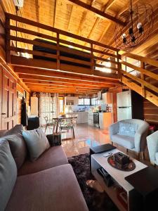 a living room with a couch and a table and a kitchen at Cabaña para 6 personas en Calamuchita - Córdoba - "La Concepción" in Embalse Rio Tercero