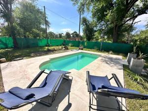 a pair of chairs and a swimming pool at Cabaña para 6 personas en Calamuchita - Córdoba - "La Concepción" in Embalse Rio Tercero +6 photos