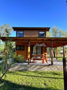 a log cabin with a picnic table in front of it at Cabaña para 6 personas en Calamuchita - Córdoba - "La Concepción" in Embalse Rio Tercero