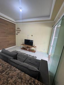 ein Wohnzimmer mit Sofa und Fernseher in der Unterkunft Casa da lagoa in São Pedro da Aldeia