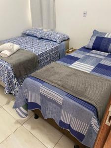 two beds sitting next to each other in a room at Flat aconchego PNz in Petrolina