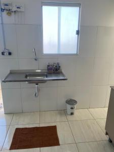 a bathroom with a sink and a window at Flat aconchego PNz in Petrolina