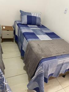a blue and white bed in a room at Flat aconchego PNz in Petrolina