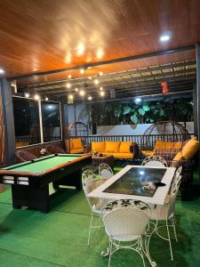 LuksuhinD LUXE Garden Resort的配有台球桌和一些椅子的房间