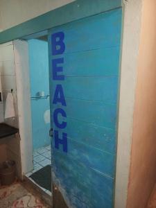 een badkamer met een blauwe deur waarop de woorden 'wees een gast' staan bij Sayu Life in Sayulita