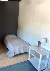 a bedroom with a bed and a table with a lamp at Monoambiente Noah 2 in Ezeiza