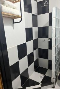 a bathroom with a black and white checkered wall at Monoambiente Noah 2 in Ezeiza +13 photos