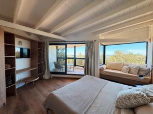 a bedroom with a bed and a couch and a balcony at Casa Jacana in Maldonado