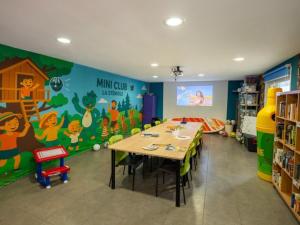 a classroom with a table and a wall with a mural at Mobil home 32m² avec terrasse, 3 chambres pour 6 personnes - API-1-52-713 in Barbey-Séroux