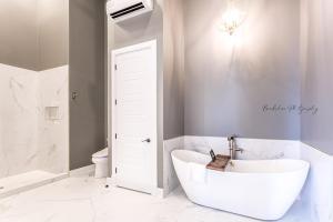 BatesvilleThe Royal on Main的带白色浴缸和马桶的浴室