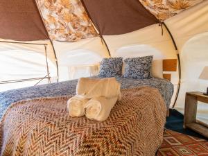 El RosarioLa Colmena Glamping Obrera的帐篷内的一张床位,上面有两条毛巾