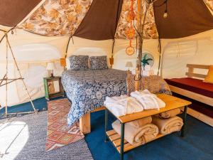 El RosarioLa Colmena Glamping Obrera的帐篷内带一张床和一张桌子的房间