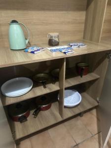 a wooden shelf with plates and a teapot on it at E Lindo Sobrado com 2 quartos em condomínio - Centro in Marília +14 photos