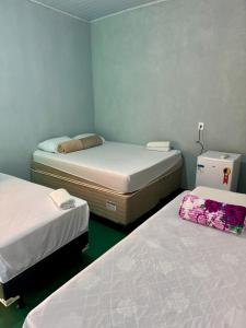 two beds in a small room with twoperate beds at Pousada e Camping São José in Manhã