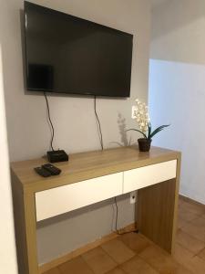 a flat screen tv hanging on a wall at E Lindo Sobrado com 2 quartos em condomínio - Centro in Marília