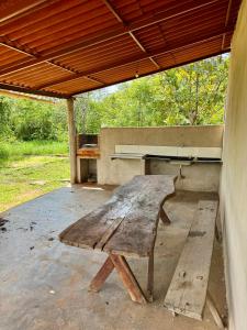 a large wooden bench sitting under a pavilion with a piano at Pousada e Camping São José in Manhã