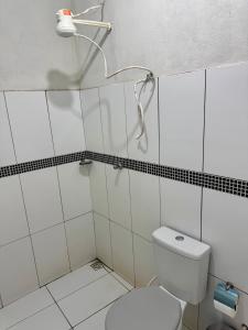 a white bathroom with a toilet and a shower at Pousada e Camping São José in Manhã
