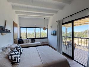 a bedroom with a large bed and a balcony at Casa Jacana in Maldonado +4 photos