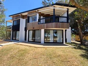 a house with a balcony on top of a yard at Casa Jacana in Maldonado