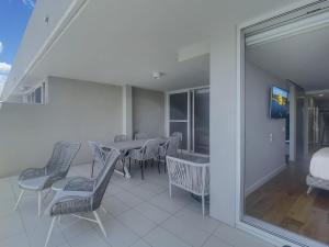 ein Esszimmer mit Tisch und Stühlen auf einem Balkon in der Unterkunft Spacious Modern Apartment in Batemans Bay in Batemans Bay