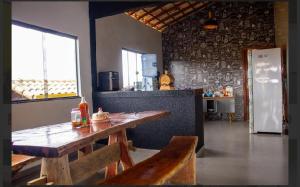 a kitchen with a wooden table in a room at Casa amarela in Santana do Riacho