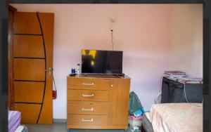 a bedroom with a dresser with a television on it at Casa amarela in Santana do Riacho