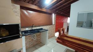 a bathroom with a sink and a mirror and a bench at Casatemporadapadilha in Olímpia