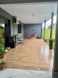 a large room with a wooden floor with plants at Casa Aconchego da Vó Gera in Foz do Iguaçu +2 photos