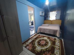 a small bedroom with a bed and a rug at Casa Aconchego da Vó Gera in Foz do Iguaçu