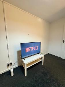 a flat screen tv sitting on a table in a room at Bright and Spacious 2 Bed Flat Sleeps 5 in Nottingham