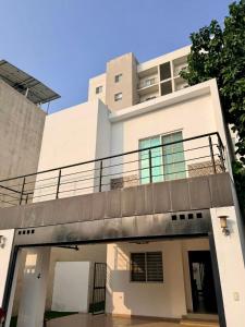 een wit gebouw met een balkon erboven bij Moderna Casa Céntrica in Monterrey