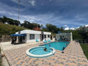 a swimming pool with several people in it at Finca Cimarrones Robles 