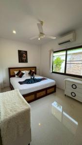 een slaapkamer met een bed en een plafondventilator bij Lai Thai Villa 4 in Rawai Beach