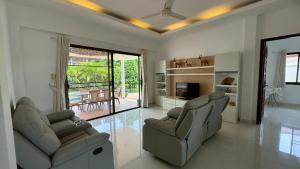 een woonkamer met 2 banken en een televisie bij Lai Thai Villa 4 in Rawai Beach +10 foto's