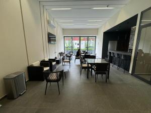 una stanza con tavoli e sedie e una persona seduta a un tavolo di Depa - Estadio Guadalajara - Ciudad Judicial a Guadalajara