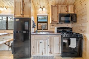 a kitchen with wooden cabinets and a black refrigerator at Cozy ski cabin #3, 3 beds in Bethel