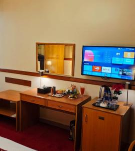 a hotel room with a desk and a flat screen tv at Golden California Hotel in Dubai