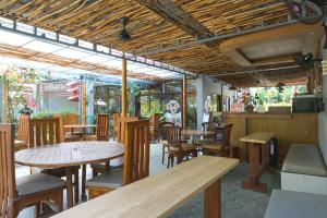 an empty restaurant with wooden tables and chairs at Komodo Lodge in Labuan Bajo