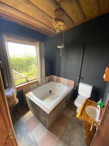 a large bath tub in a bathroom with a toilet at Cabana Rústica em Piedade in Piedade +23 photos