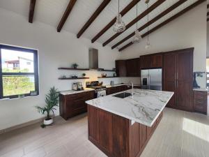 eine große Küche mit Holzschränken und einer Marmoroberfläche in der Unterkunft Sunset Oasis Waterfront in Maya Beach