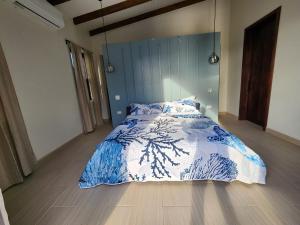 ein Schlafzimmer mit einem Bett mit einer blau-weißen Bettdecke in der Unterkunft Sunset Oasis Waterfront in Maya Beach + 5 Fotos