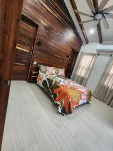 ein Schlafzimmer mit einem Bett und einer Holzwand in der Unterkunft Sunset Oasis Waterfront in Maya Beach