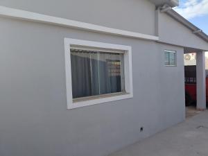 una finestra sul lato di un edificio bianco di Kitnet Boa Vista a Sete Lagoas