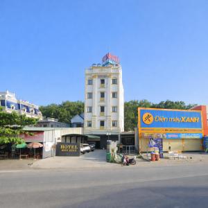 een hoog wit gebouw met een bord ervoor bij Bình Minh Hotel Bình Dương in Xóm Bưng