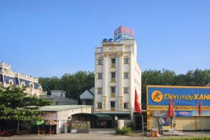 een wit gebouw met een bord ervoor bij Bình Minh Hotel Bình Dương in Xóm Bưng