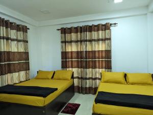 twee bedden in een kamer met gordijnen bij Stream Inn Haputale in Haputale