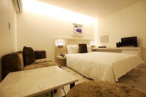 a hotel room with a bed and two chairs at 청주 호텔 린 in P'ungnyŏn-gol