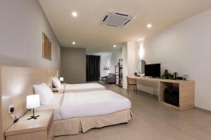 een slaapkamer met een bed en een bureau met een televisie bij Golden View Serviced Apartments in George Town +58 foto's