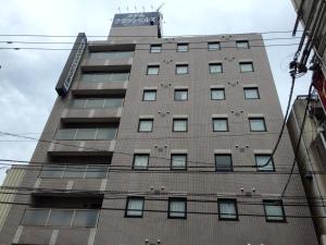 a tall building with a sign on top of it at Hotel Crown Hills Toyama in Toyama